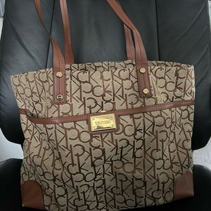 Tan/khaki Calvin Klein bag. Large front pocket - 2 smaller pkgs in back 3 inside